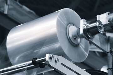 Machine for packing food or pharmaceutical products in polyethylene film, the packaging film roll above the conveyor belt is ready to work