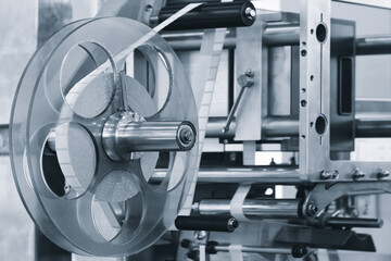 A roll of white paper is passed through the machine. printer and sticker machine, which is used for printing and applying stickers to packaging industrial products. Concept of precision efficiency