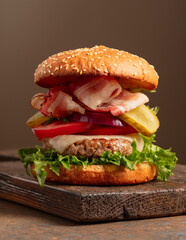 Fresh tasty burger on a wooden cutting board.