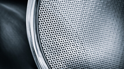 Close up of a metal mesh with a lot of holes. The mesh is silver and has a shiny appearance