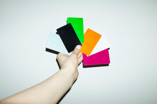 Hand holding many colourful finance money payment credit debit cards 