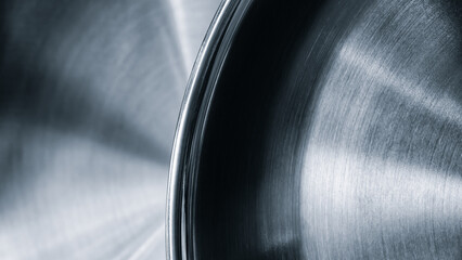 Silver frying pan with black rim. The frying pan is shiny and has a smooth surface as abstract metallic texture background for web banner template page