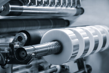 Machine for packing food or pharmaceutical products in polyethylene film, packaging film roll above the conveyor belt is ready to work.