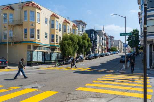 San Francisco, United States - 12 September 2025: View of Chestnut Street under a bright sky, its colorful buildings lining the road, as pedestrians cross at the yellow striped crosswalks.
