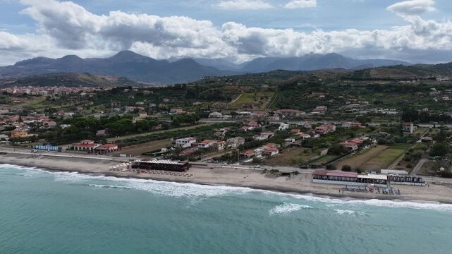 Aerial drone view of Campofelice di Roccella, a charming Sicilian seaside village in northern Sicily, Italy, showing traditional holiday homes, coastline, and panoramic Tyrrhenian Sea vistas