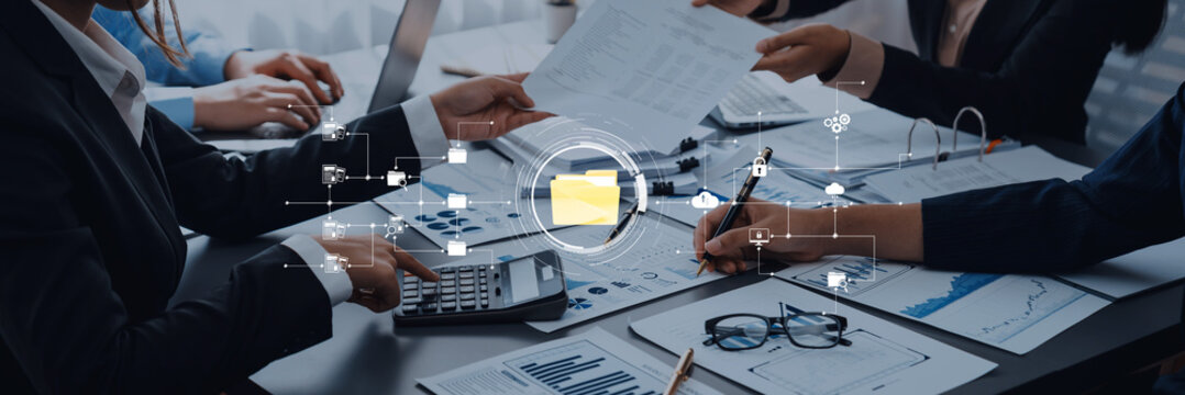 Professionals Collaborating in Modern Office Environment Analyzing Business Documents with Technology and Data Visualization on Table Trope. - Powered by Adobe