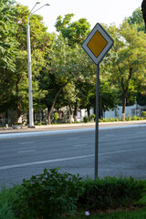 Priority Road Sign on Tree-Lined Street