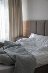 Sunlight falls on a bed in a bedroom.