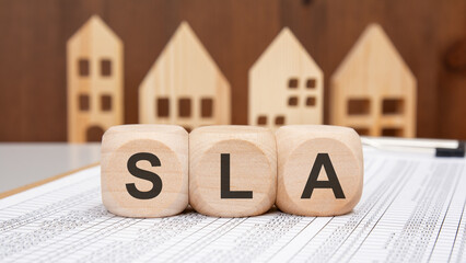 wooden blocks with SLA word on financial spreadsheet background