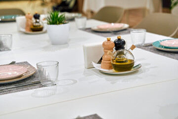 A Tasteful Dining Table Setting Featuring Olive Oil, Condiments, and Elegant Tableware for a Memorable Culinary Experience