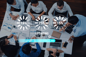 A top-down view of a diverse team collaborating in a modern office setting with visual progress indicators showing project updates, enhancing productivity and creativity. Trope