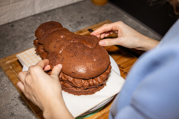 Woman making a chocolate cake snowman shaped.