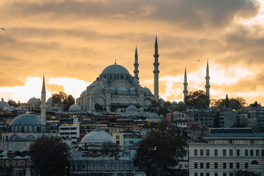 View of the majestic S&Atilde;&frac14;leymaniye Mosque against a backdrop of warm, amber skies and scattered birds, showcasing the architectural brilliance, Istanbul, &Auml;&deg;stanbul, T&Atilde;&frac14;rkiye.