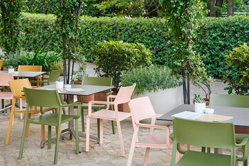 Outdoor Dining Area with Colorful Chairs and Lush Greenery Creating a Relaxing Atmosphere for Guests to Enjoy Meals in Nature's Embrace