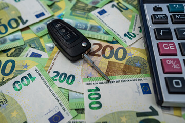 Euro bills with calculator and car key representing vehicle financing, investment and budgeting concept