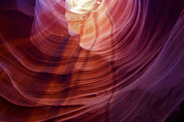 View of swirling sandstone walls, bathed in hues of magenta and orange, create a mesmerizing dance of light and shadow in the canyon, Antelope Canyon, Arizona, United States.