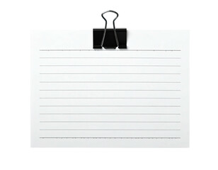Lined white paper held by a black metal binder clip against a black background
