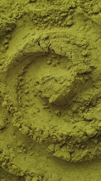 Green chlorella algae powder on a wooden spoon, top view. Healthy nutritional supplement.