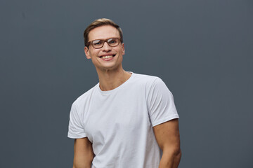 Obraz premium smiling young caucasian man wear glasses white t-shirt look camera isolated on dark gray background work from home digital nomad concept