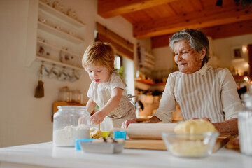 Christmas baking tradition with grandma and little kid.