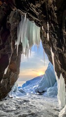 Ice cave opening on a winter morning.  Sunlight streams through an icy cave entrance, illuminating frozen landscape beyond.  Icicles hang from the cave walls