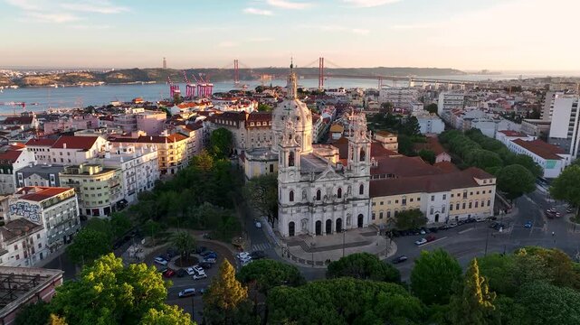 Aerial view of Estrela Basilica, bridge and city buildings with contrasting colors under the sunlight, Lisbon, Lisbon, Portugal.