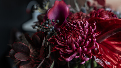 Autumn atmospheric flower arrangement. dark burgundy purple demonic bouquet on a black background....