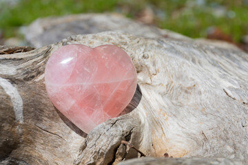 A close up image of a heart shaped rose quartz crystal