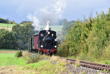 Obraz premium Schmalspur - Museumsbahn auf dem Härtsfeld mit Dampflokomotive, Personenwagen, Triebwagen in herbstlicher Landschaft