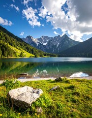 Serene alpine lake, vibrant green shore, towering peaks under a bright blue sky