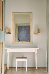 Elegant Interior Design Featuring a Stylish Console Table, Cozy Stools, and a Beautiful Wall Mirror Enhancing the Modern Living Space Ambiance