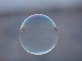 ﻿Schimmernde Sphäre: Eine Seifenblase im Fokus der Stille.