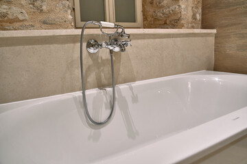A Serene Bathtub Scene Highlighting Elegant Bathroom Fixtures and Natural Stone Walls for a Relaxing Home Spa Experience