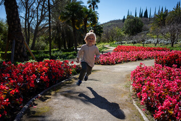 A joyful child running through a garden path, surrounded by vibrant pink flowers, capturing the essence of a playful and carefree day in nature