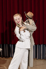 An actor performs on the theatre stage with his coat on a hanger.