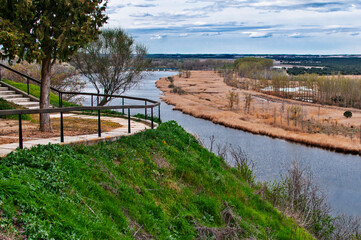 Fototapeta premium River winding through marshland with path on hillside