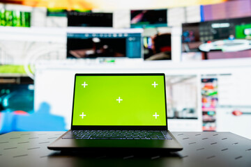 Close up of green screen laptop and VOD entertainment channels video collage. Chroma key notebook in front of virtual background displaying social network feed activity digital dashboard