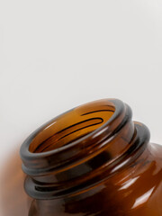 Close up of open brown glass bottle with white background