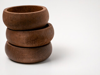 Stack of three round wooden bowls on white background minimalist composition
