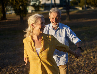 Happy active senior couple having fun in park outdoors