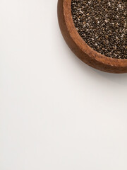 Chia seeds in wooden bowl on white background with copy space