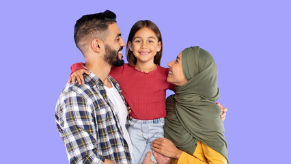 Muslim Family Embracing Posing Together On Blue Background. Studio Shot Of Happy Middle Eastern...