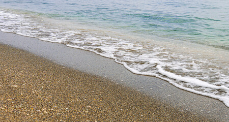 Small wave edge breaking on wet sand.