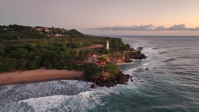 Aerial drone video of El Faro Park with Punta Hig&uuml;ero Lighthouse on the western side of Puerto Rico in Rincon at dusk