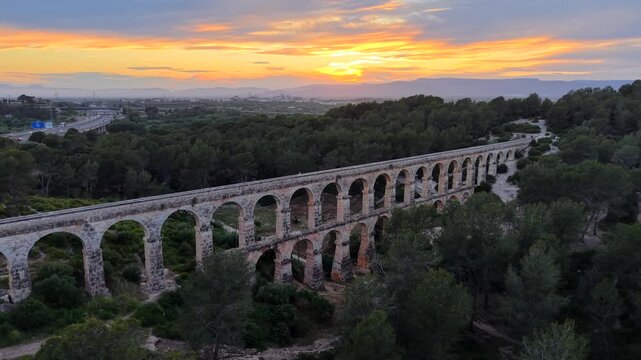 Aerial drone video of The Ferreres Aqueduct (Pont del Diable), an ancient Roman aqueduct near the city of Tarragona in Catalonia, Spain at sunset