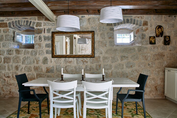 Elegant Dining Area with Rustic Stone Walls, Modern Lighting, and Stylish Furniture for Cozy Gatherings and Memorable Meals