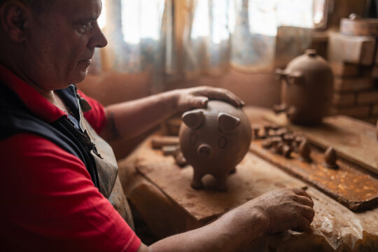Potter making clay vessels in workshop