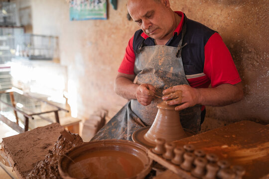 Potter making clay vessels in workshop