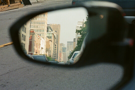 View of downtown Montreal neighbourhood in a car glass mirror