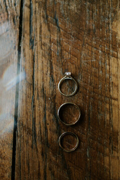 three wedding rings on a vintage wood floor